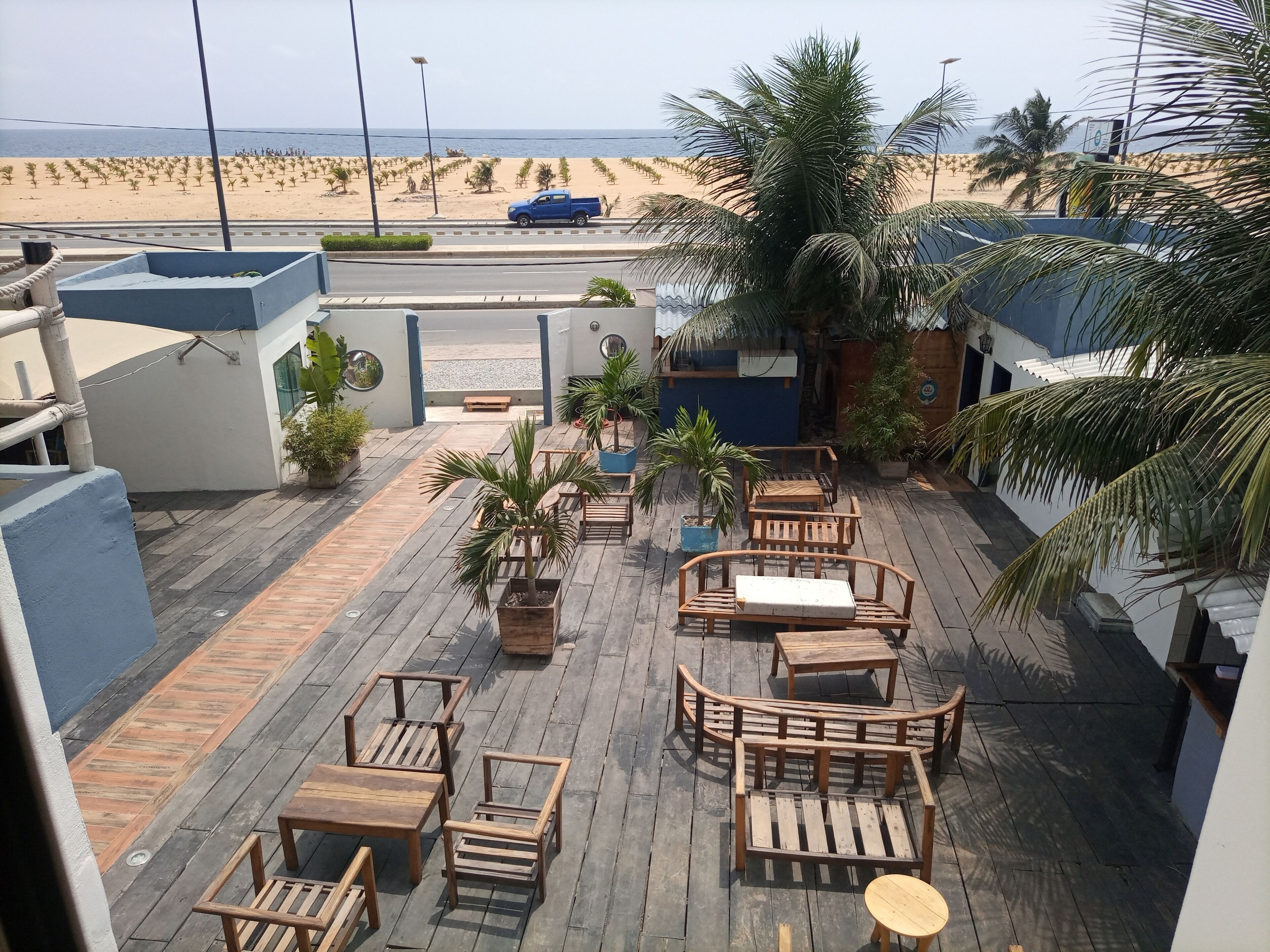 Une terrasse en bois, dotée de mobilier d’extérieur, qui offre une vue sur la plage.