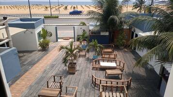 Une terrasse en bois, dotée de mobilier d’extérieur, qui offre une vue sur la plage.