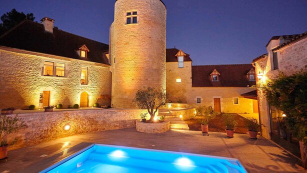 A stone building with a tower, a swimming pool, and a courtyard with potted plants. - Chambres d'hôtes La Tour de Ginaillac (Les Arques)
