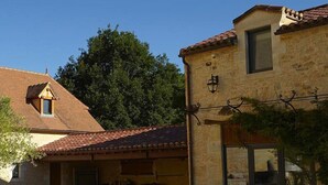 A poolside area with a stone building, a covered patio, and a clear sky. - Chambres d'hôtes La Tour de Ginaillac (Les Arques)