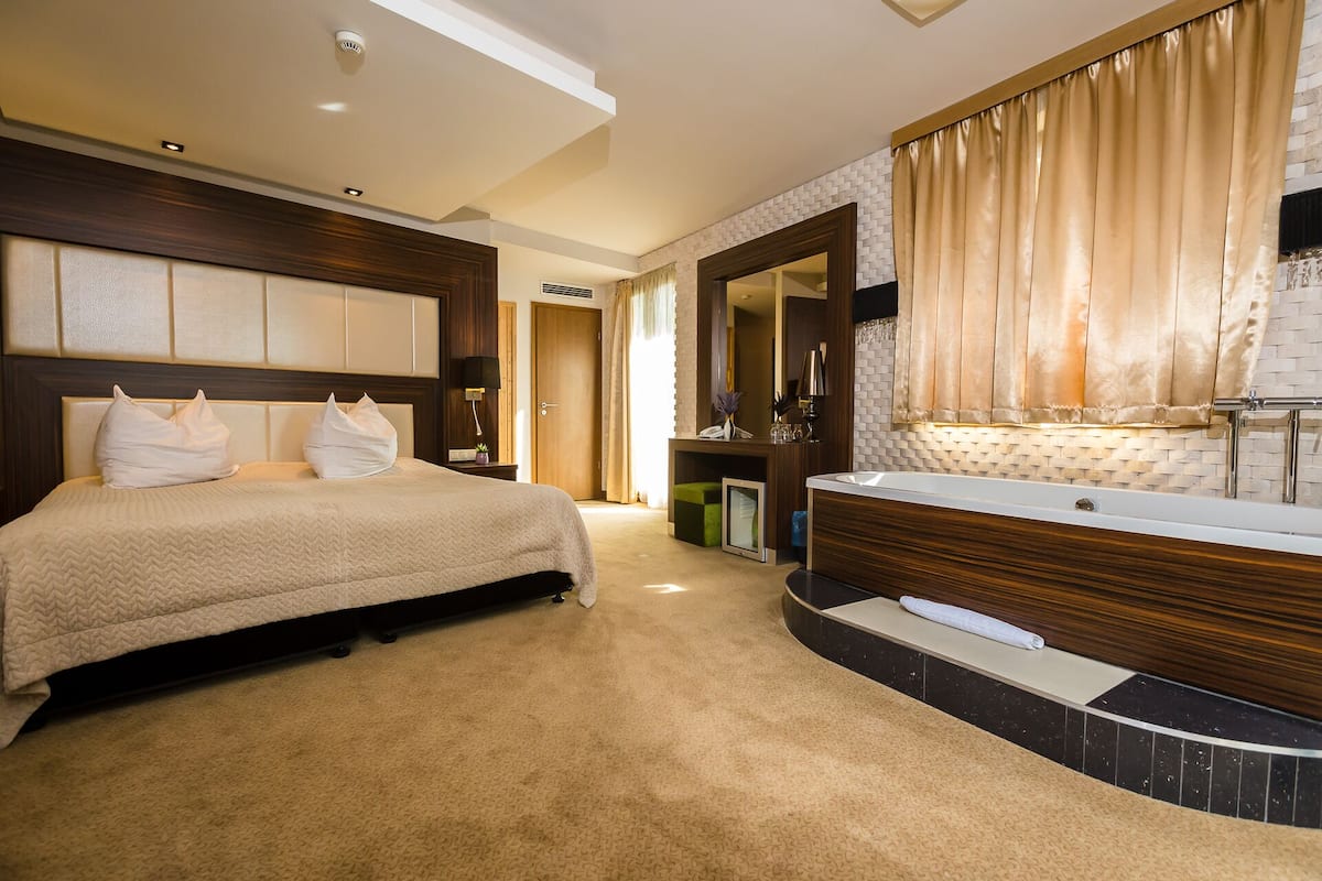 Une chambre d’hôtel avec un grand lit, une coiffeuse avec un miroir et une salle de bain.
