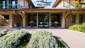 A building with a sign reading "DUNA GARDEN" and a covered entrance. - Duna Garden Hotel (Budapest)