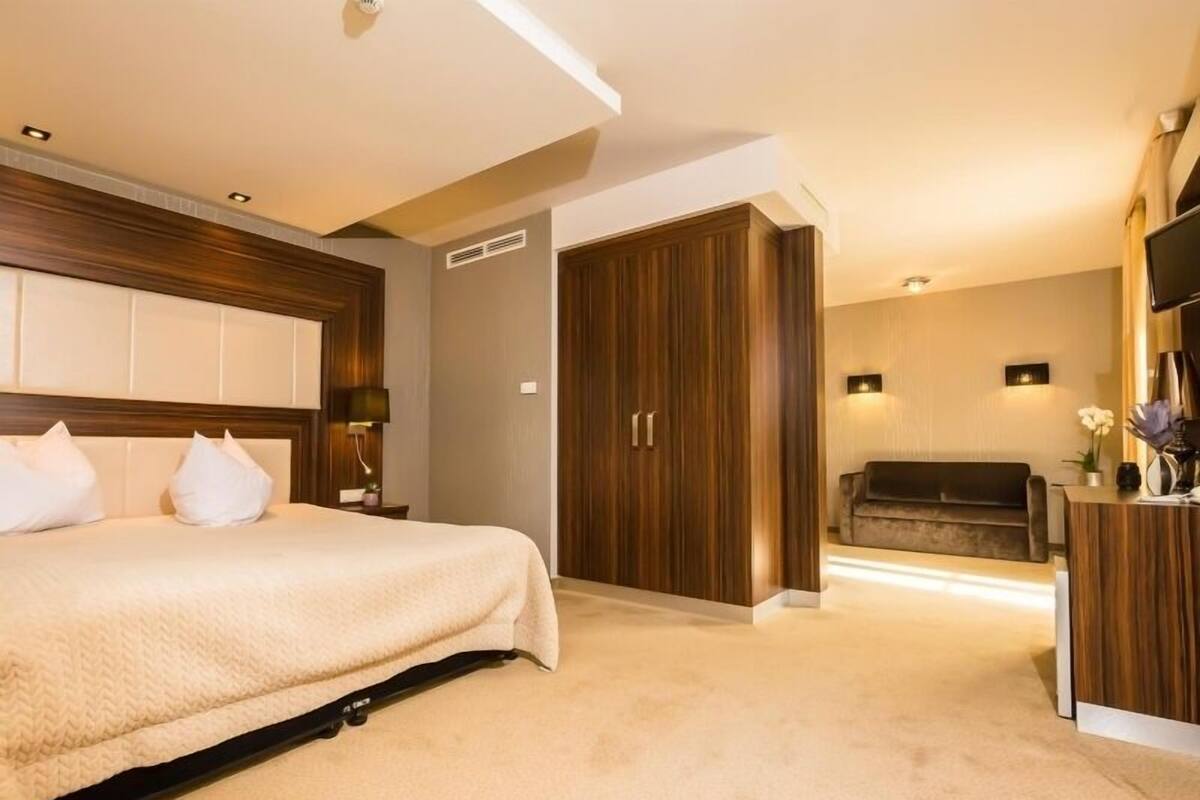 Une chambre à coucher comprenant un lit, une armoire, un bureau et un téléviseur.