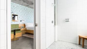 Uma casa de banho moderna com chuveiro, toucador e cama.
