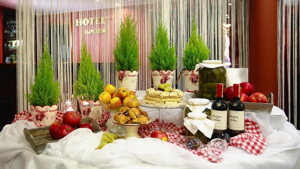 A hotel reception area with a table set for a buffet, featuring various food items and wine bottles.