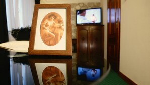 A framed photograph on a reflective surface with a television in the background.