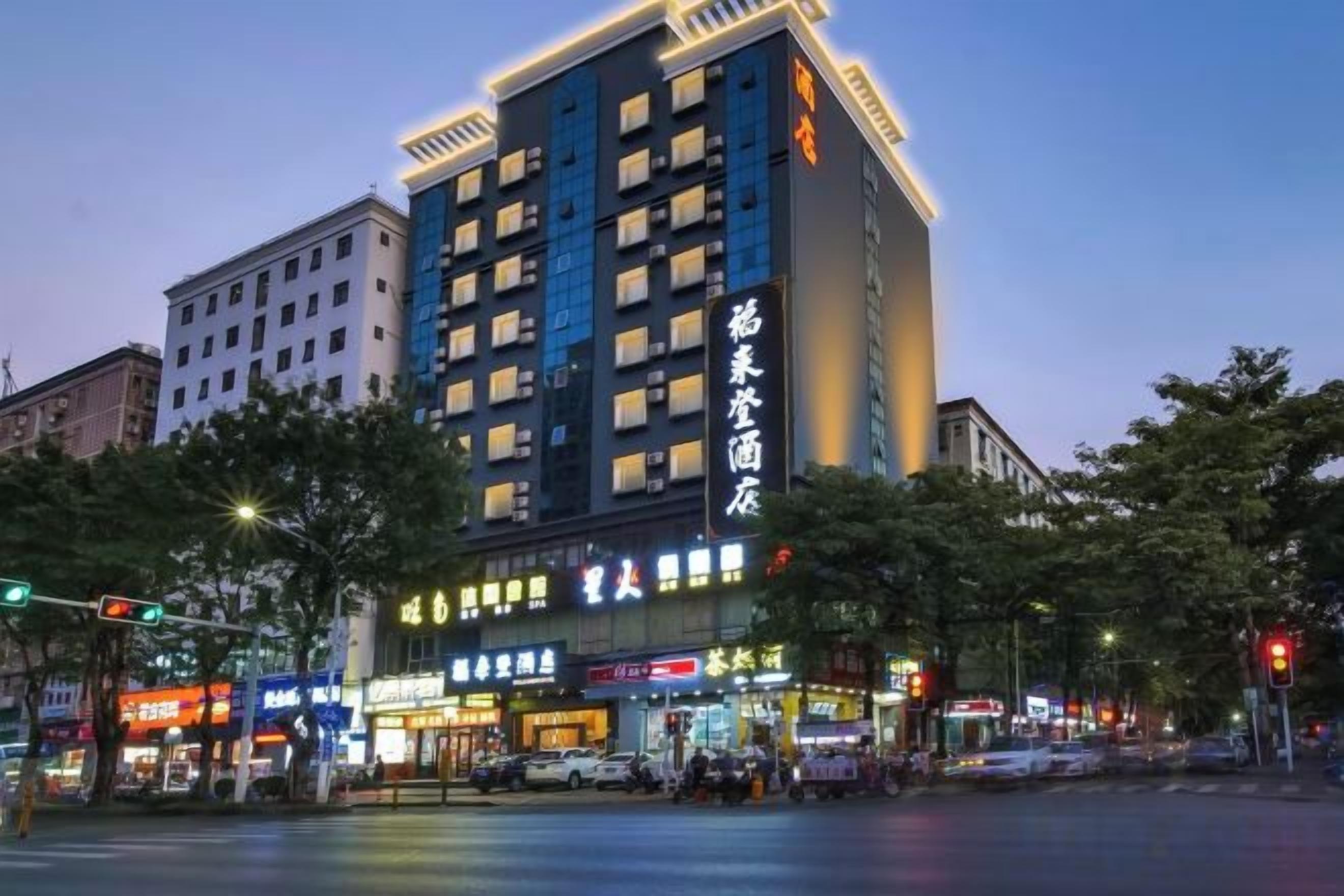 A multi-story hotel with illuminated signage, located at a city intersection.