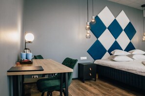 Un dormitorio moderno con cama, mesita de noche, lámpara y una pared con diseño geométrico.