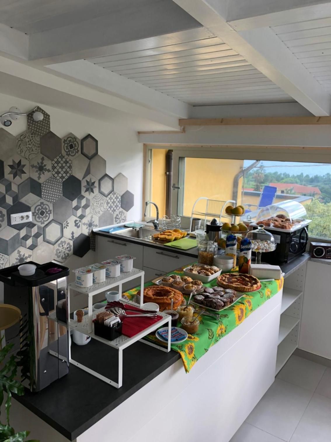 Morgenmadsbuffet med et udvalg af mad, kaffestation og udsigt til det fri.
