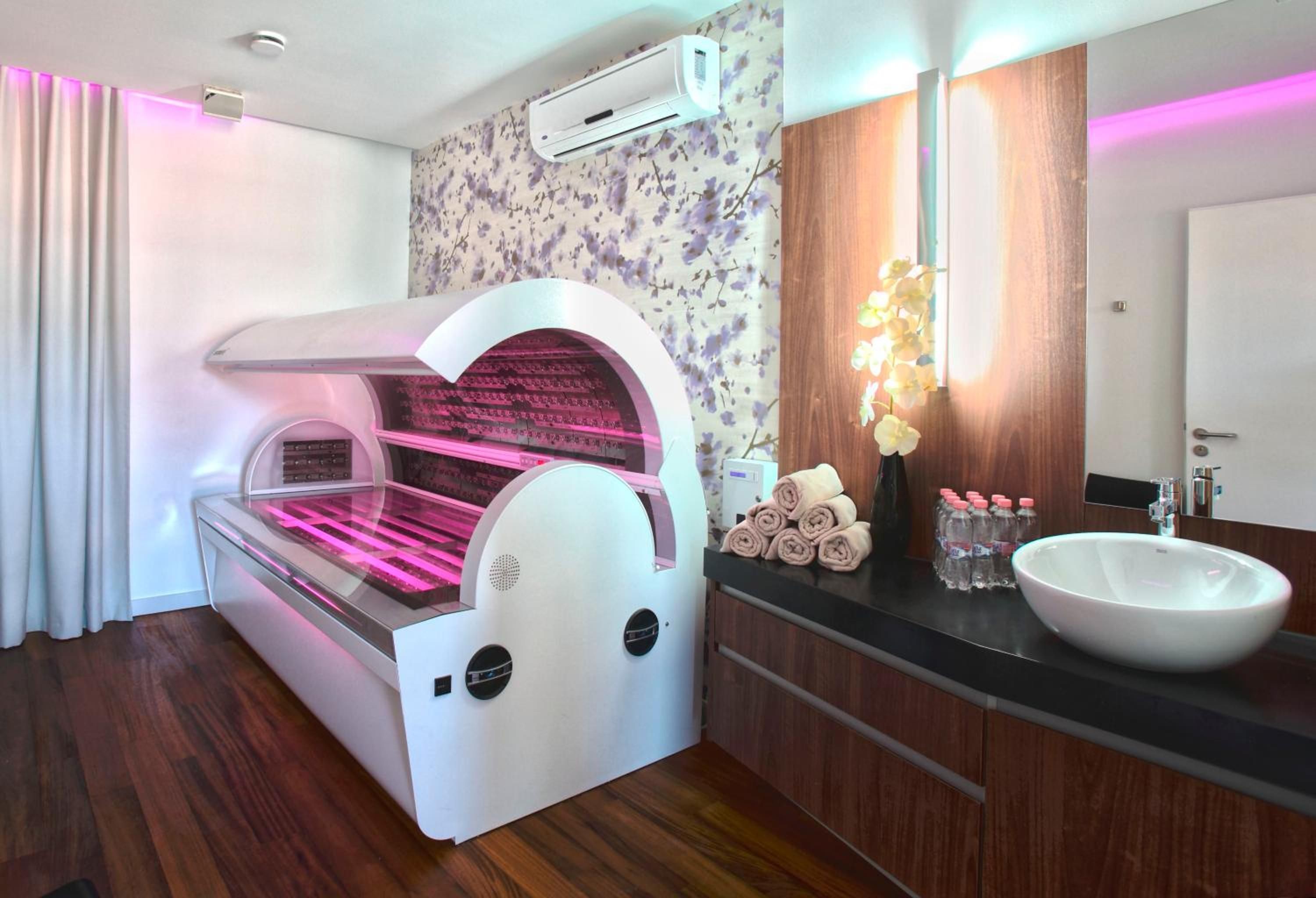 A modern bathroom with a sauna, a sink, and a mirror.