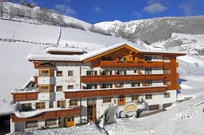 A multi-story hotel with a ski lift, surrounded by snow-covered mountains. - Bergfrieden (Martello)