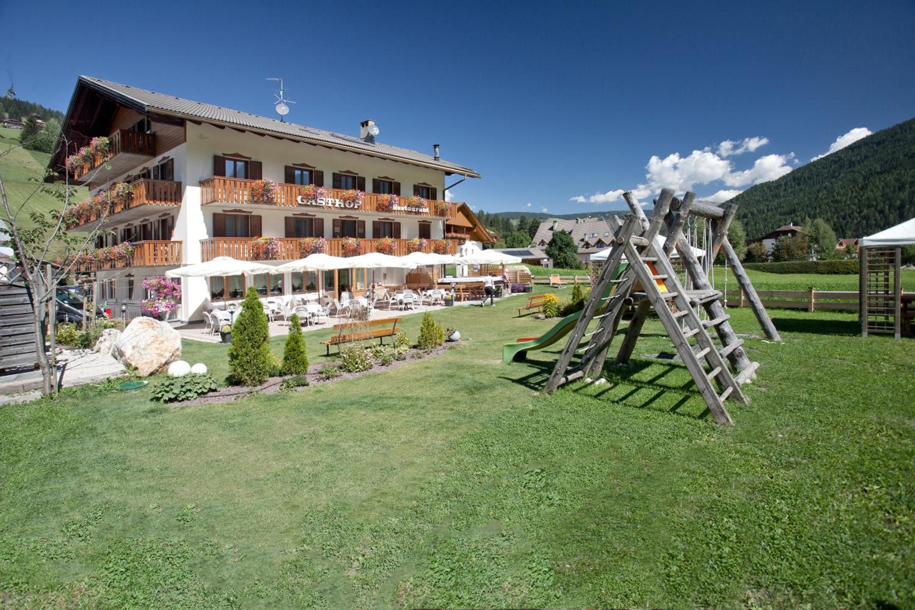 Un hôtel doté d’une terrasse et d’une structure de jeux en bois.
