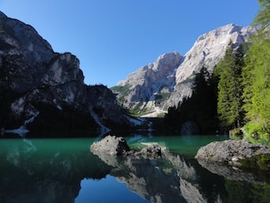 Un paisaje montañoso con un lago cristalino que refleja los picos circundantes.