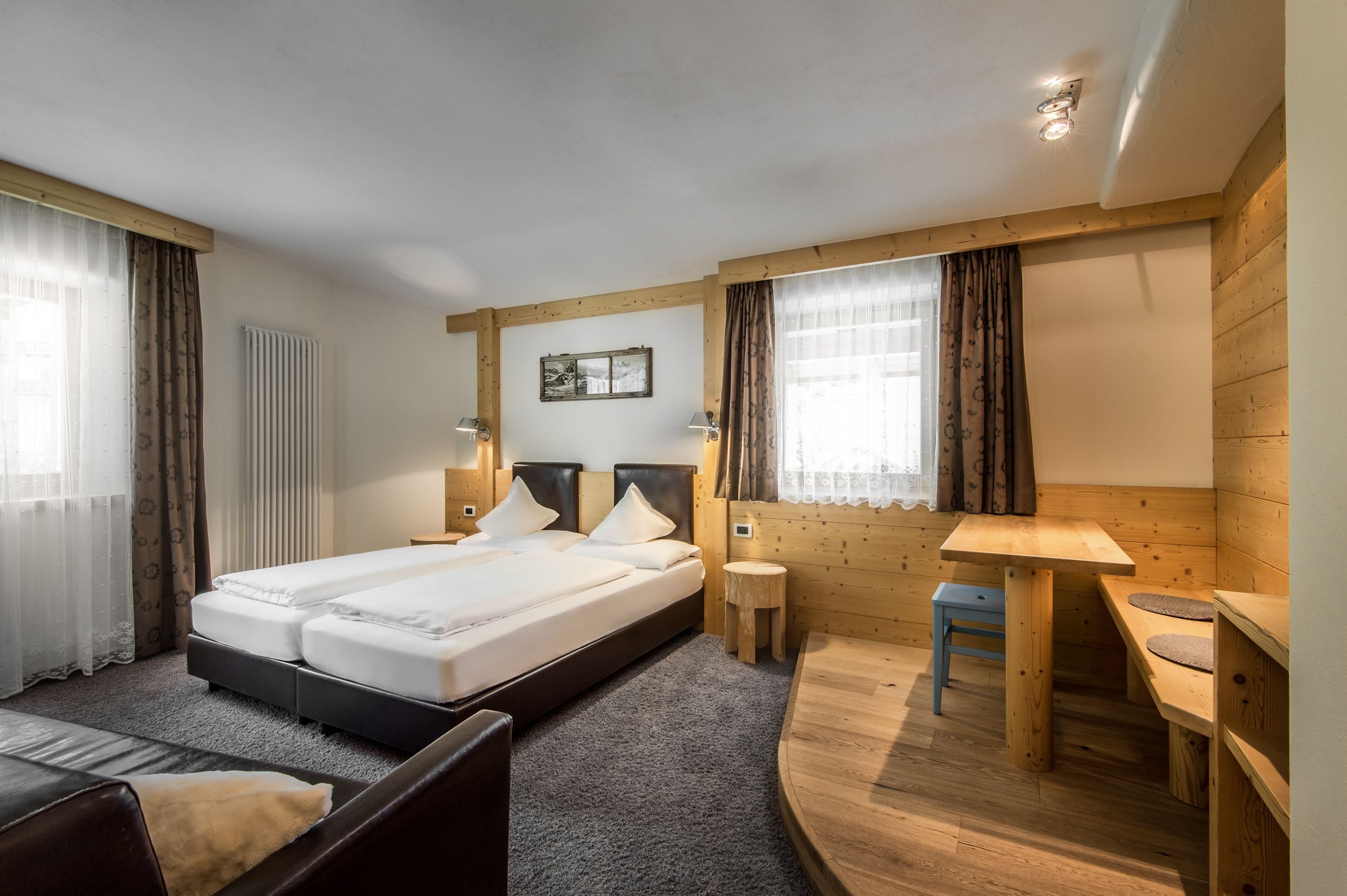 Una habitación de hotel con una cama doble, mesitas de noche, un escritorio y una silla.