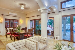 A spacious dining area with a large table, multiple chairs, and a comfortable seating area with sofas. - Tulum Luxury Collection (Tulum)
