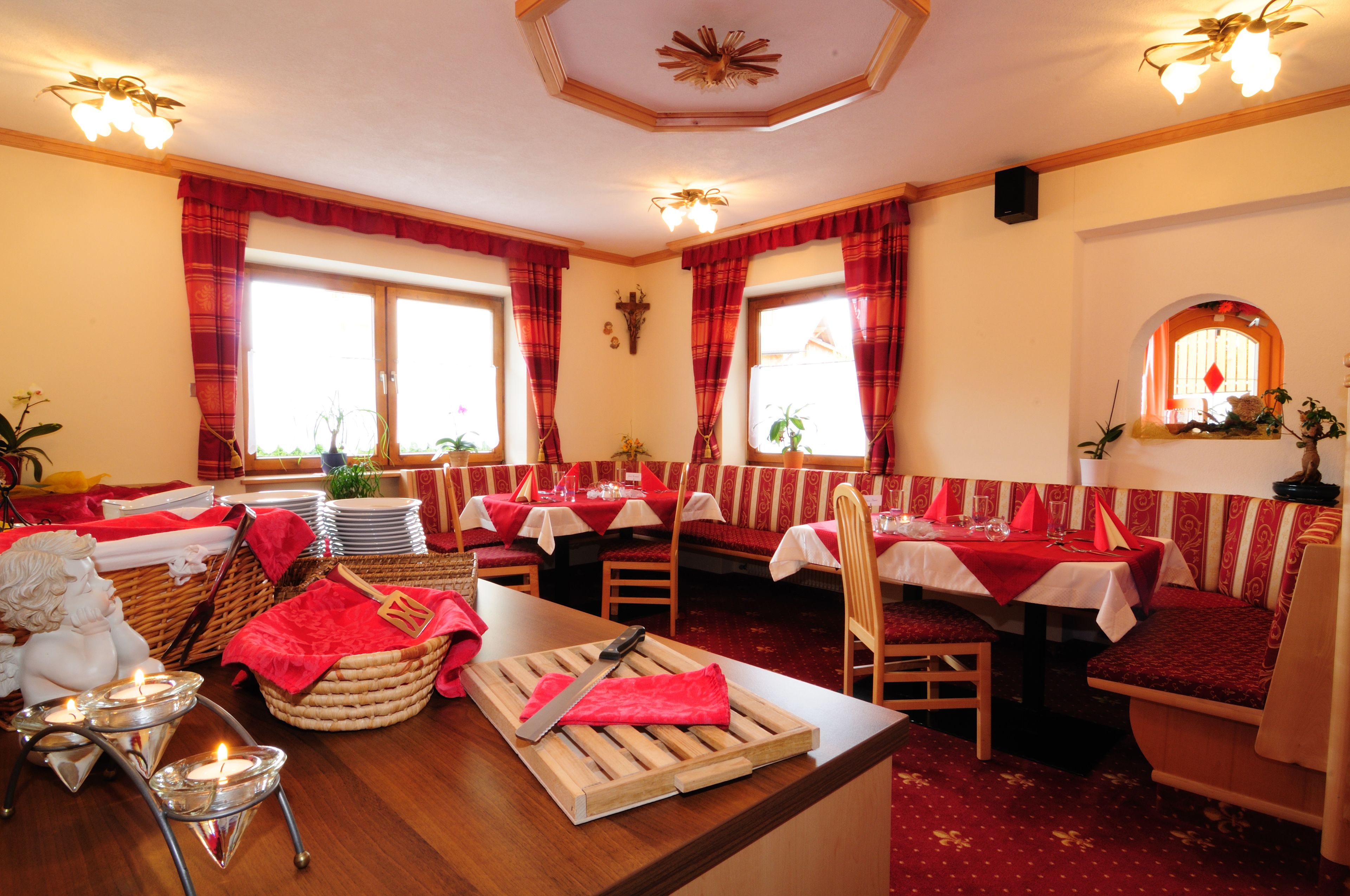 A restaurant with red and white decor, multiple tables, and chairs.
