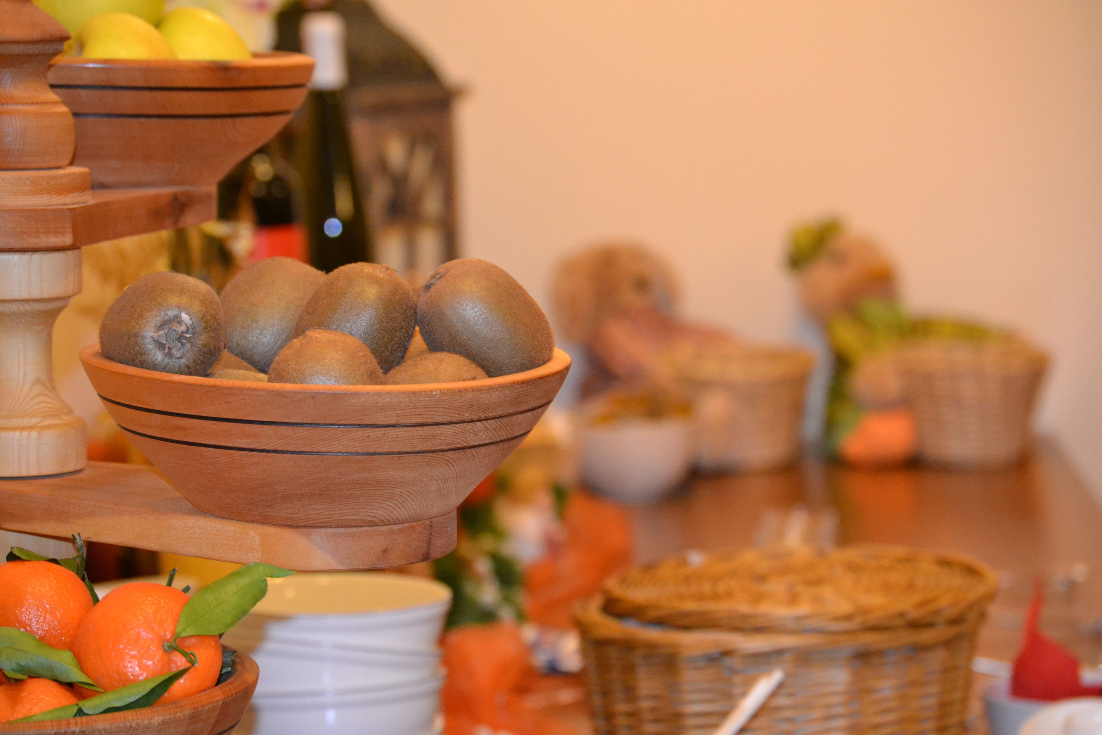 A wooden fruit stand with kiwis and oranges.