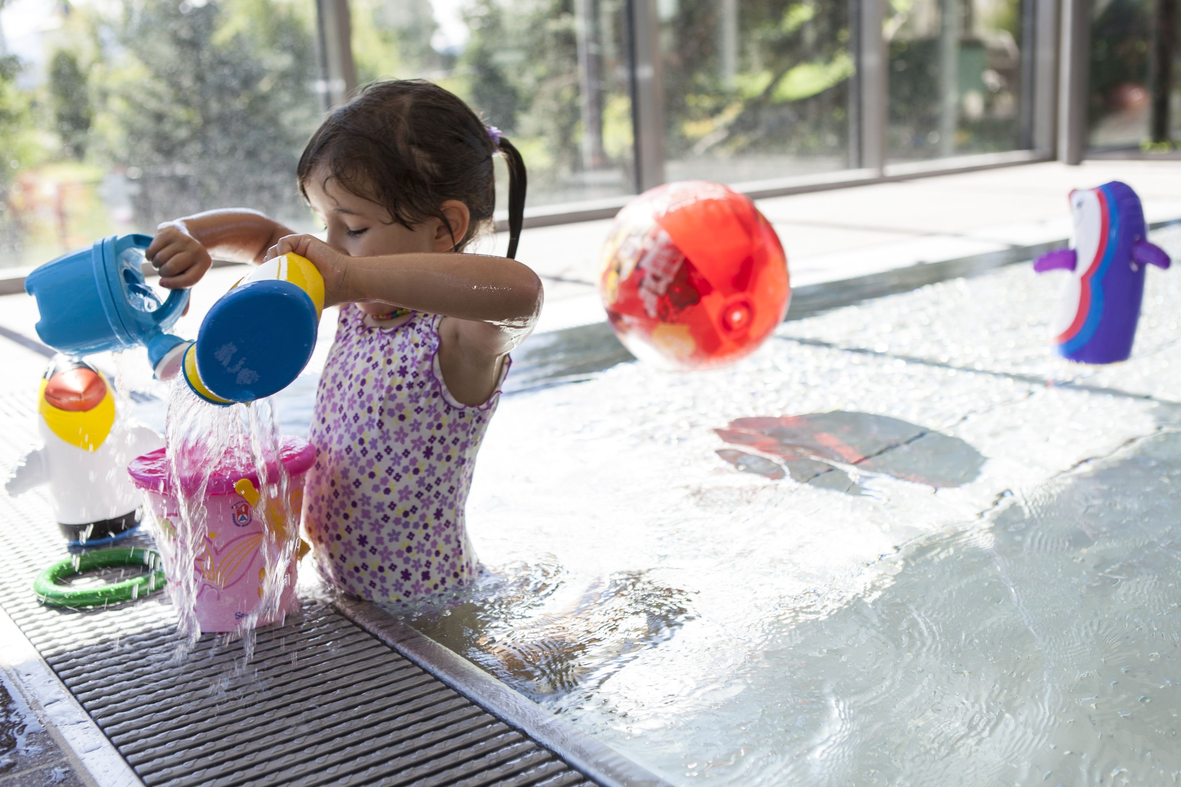 A child playing with water toys at a pool.