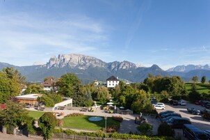 Um hotel com um pátio, área de estar externa e vista para as montanhas.