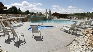 Un espace piscine avec des chaises longues et un toboggan.