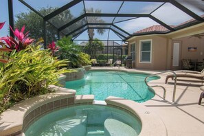 An indoor swimming pool with a glass ceiling, surrounded by tropical plants and lounge chairs. - Players Club Membership Available With Heated Pool (Naples)