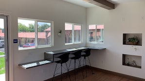 Eine moderne Küche mit integrierter Kochinsel, Barhocker und großen Fenstern mit Blick auf die Straße.