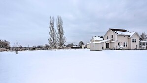 Ett stort hus i en våning med ett platt tak och ett garage på höger sida.