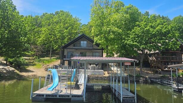 A lakeside lodge with a dock, a swimming area, and a covered seating area. - COMPLETELY REMODLED!! Gorgeous 5 BR/5.5 BA in NO WAKE cove, Dock w/12'x30' slip (Sunrise Beach)