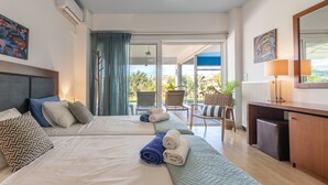 Ein Hotelzimmer mit zwei Betten, einem Schreibtisch und Blick ins Freie.