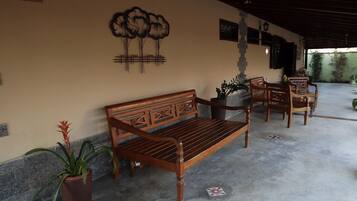 A wooden bench with intricate carvings, a potted plant, and a wall-mounted decorative piece.