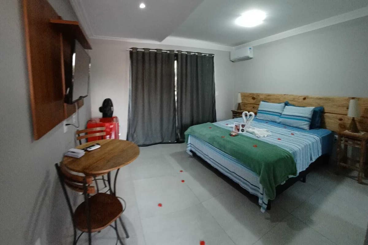 Quarto com uma cama, uma escrivaninha e uma cadeira.