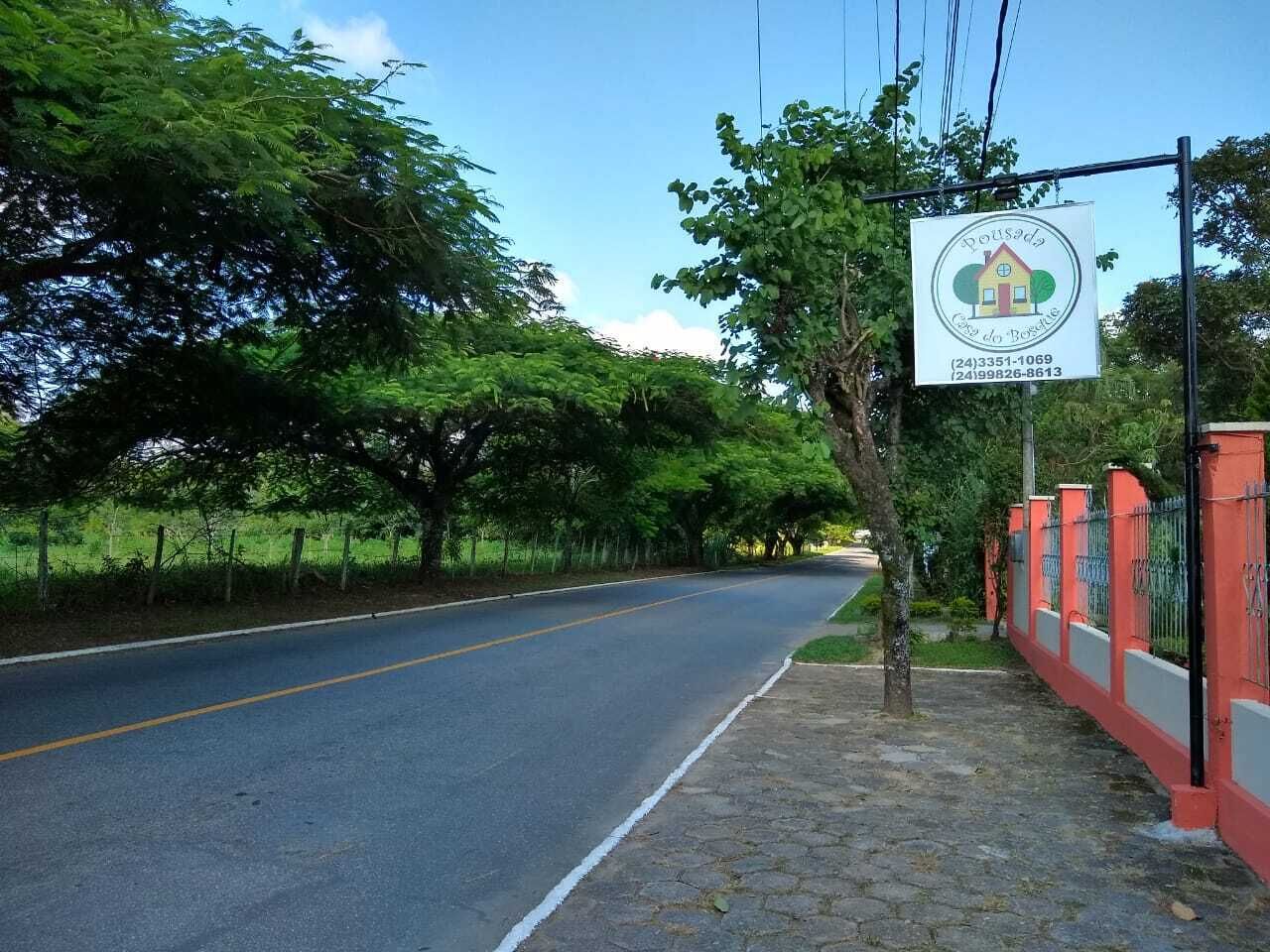 Une route avec un panneau indicateur et une clôture sur le côté droit.
