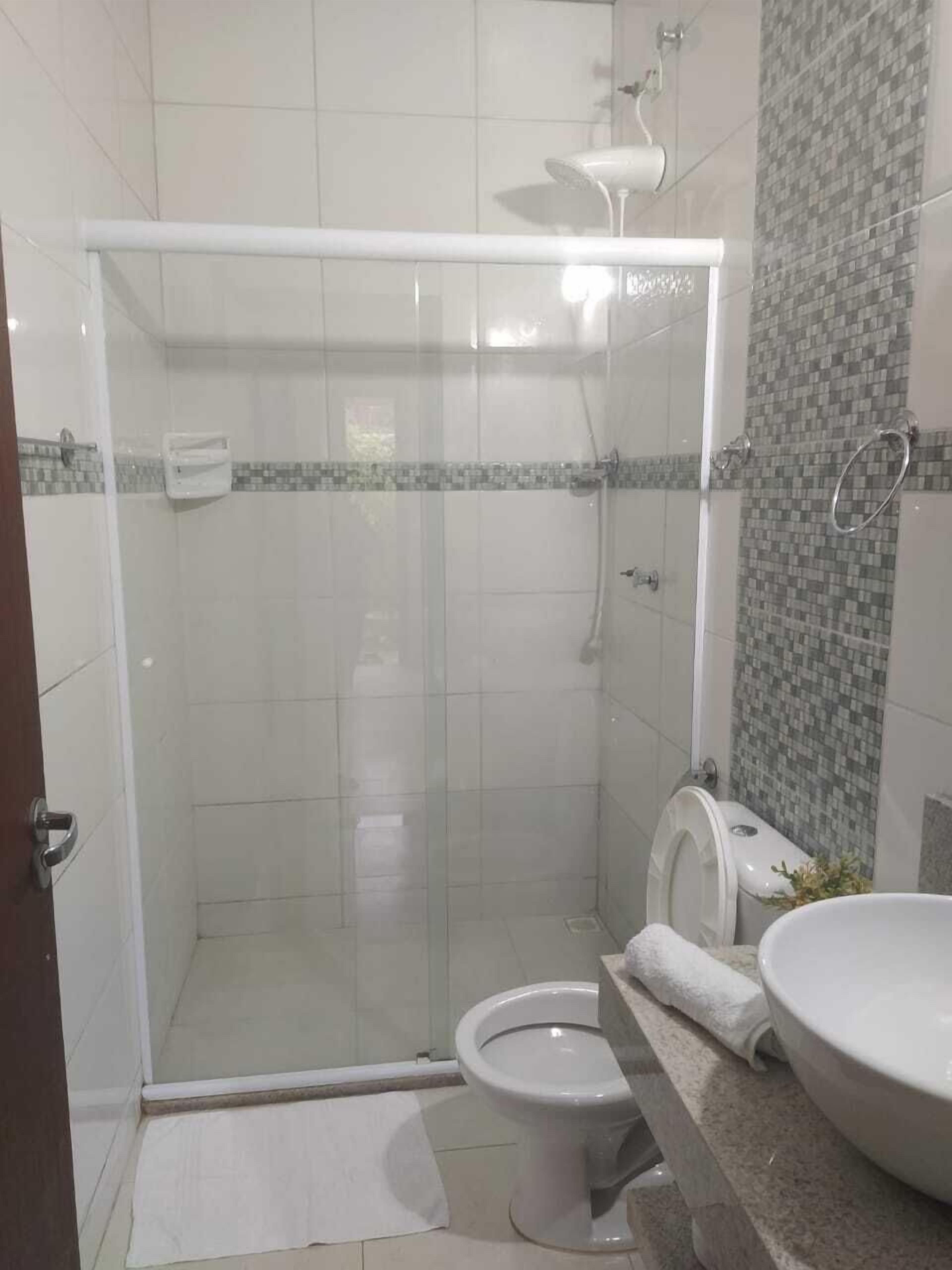 Ein Badezimmer mit Duschkabine, Toilette und Waschbecken.