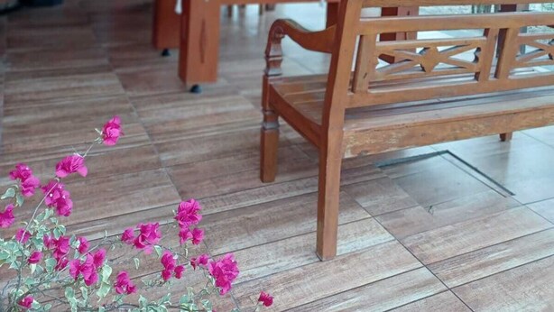 Un pavillon en bois situé à l’intérieur, doté d’un haut plafond et d’une grande table au centre.
