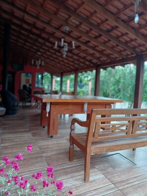 Un pavillon en bois situé à l’intérieur, doté d’un haut plafond et d’une grande table au centre.