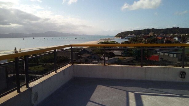 Un balcón con vista a una playa y barcos.