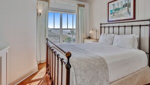 Un dormitorio con una cama grande, vistas al exterior y un cuadro en la pared.