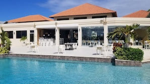 A resort with a pool, outdoor seating, and a covered bar area. - Spacious Gold Coast Townhouse in lush community close to beaches (Noord)