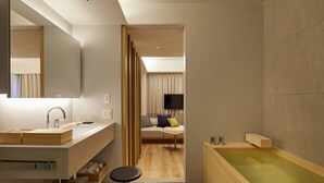 Ein modernes Badezimmer mit einem großen Spiegel, einem Waschbecken und einer Badewanne.