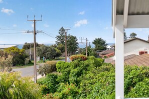 A residential area with houses, power lines, and a view of the sea.