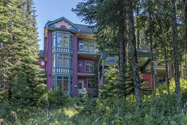 Ein mehrstöckiges Gebäude mit markanter Architektur, umgeben von dichtem Wald.