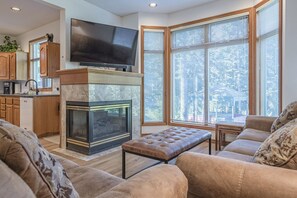 Relax by the fireplace in this inviting living room with comfortable seating and a wall-mounted TV.
