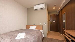 A hotel room with a bed, an air conditioner, a wooden wardrobe, and a door with a sign. - Amagasaki Plaza Hotel Hanshin Amagasaki (Amagasaki)