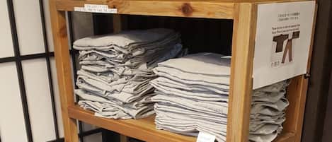 Une étagère en bois sur laquelle sont pliées et empilées des serviettes.