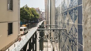 A narrow street with buildings on either side, a white van parked on the left, and a tiled wall with a blue pattern on the right. - Modern flat by Time Out Food Market (Very Central) (Lisboa)