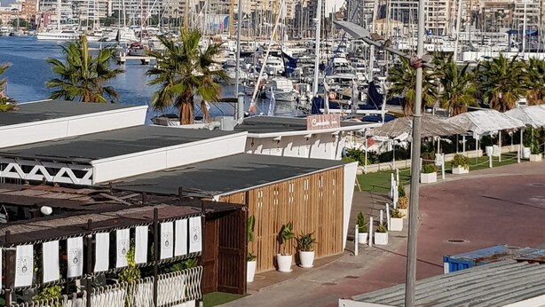 A marina with numerous boats docked, a restaurant with outdoor seating, and a clear view of the water. - Perfectly located, refurbished apartment in a gated complex with pool and garden (Torrevieja)