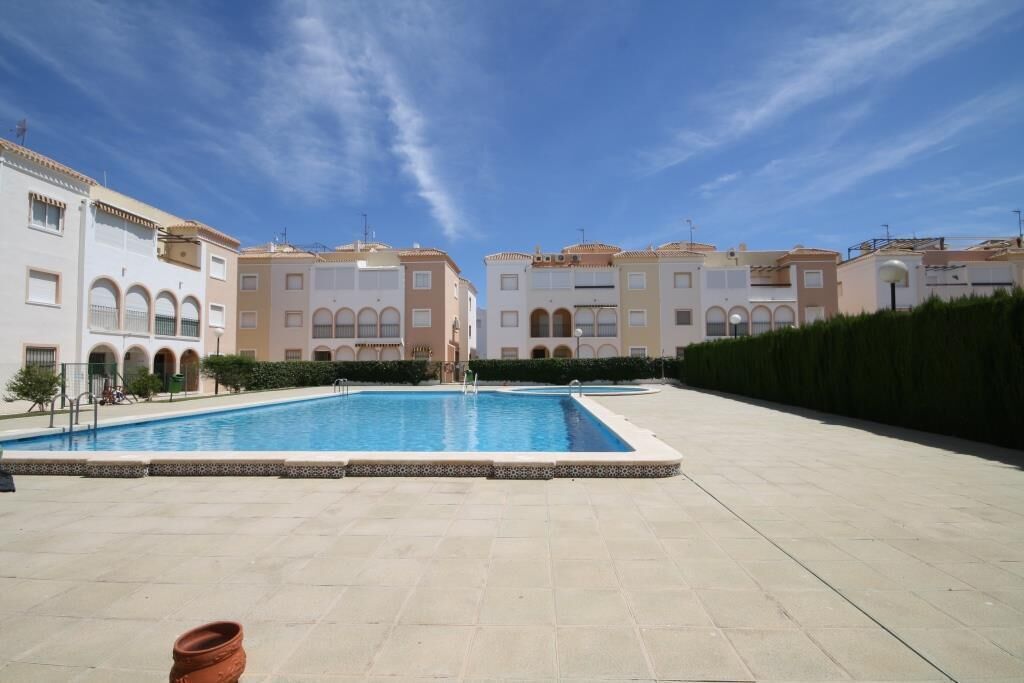 A swimming pool surrounded by multi-story buildings with arched windows and balconies.