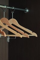 Un perchero metálico con perchas de madera.