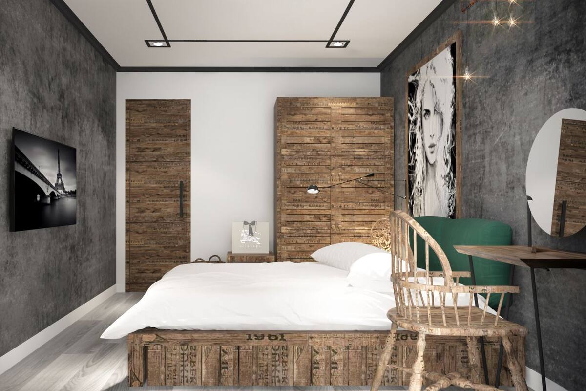 A modern bedroom with a large bed, a wooden headboard, a green chair, and a wall-mounted mirror.