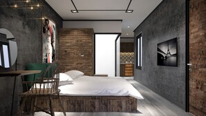 Un dormitorio moderno con una cama grande, cabecera de madera, un escritorio con silla y televisión en la pared.